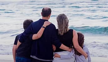 family facing the ocean